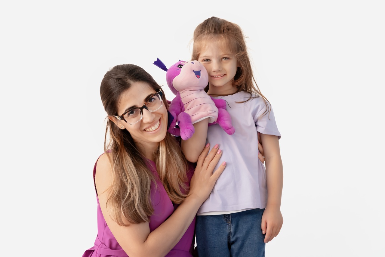 Un’insegnante e una bambina con un peluche durante un incontro Helen Doron